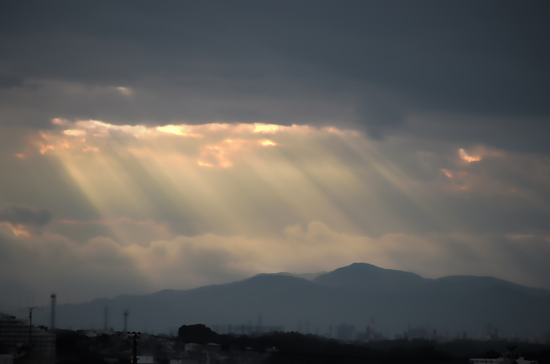 Sunbeams breaking through dark clouds over the mountains, a picture of hope for prayers for encouragement