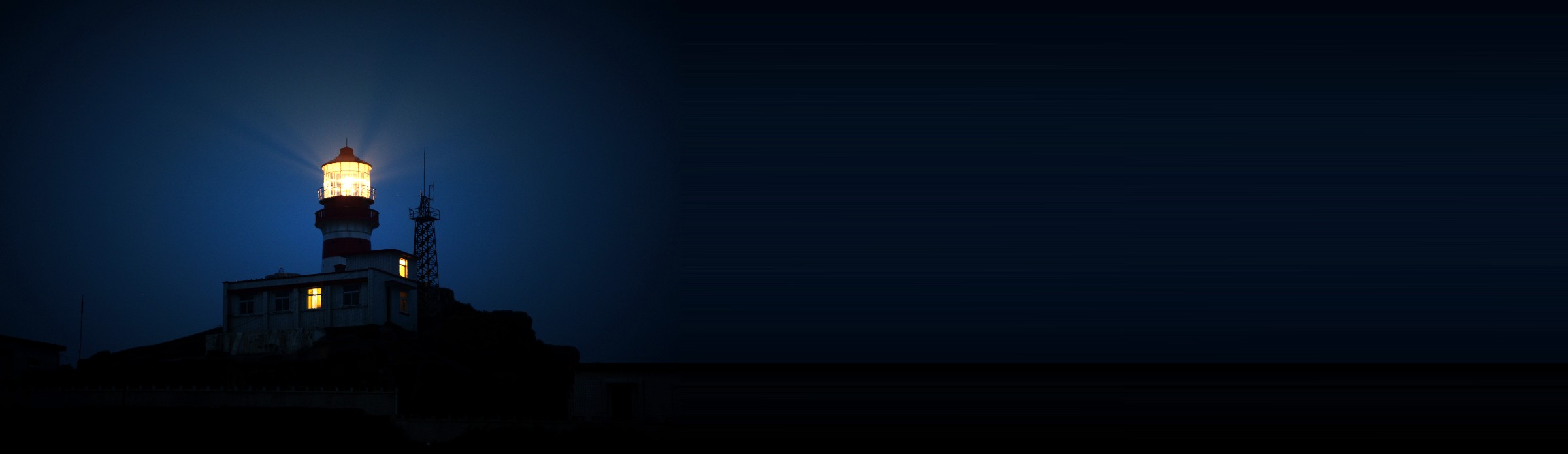 Lighthouse shining its light against a dark night sky, representing prayers for safety and protection
